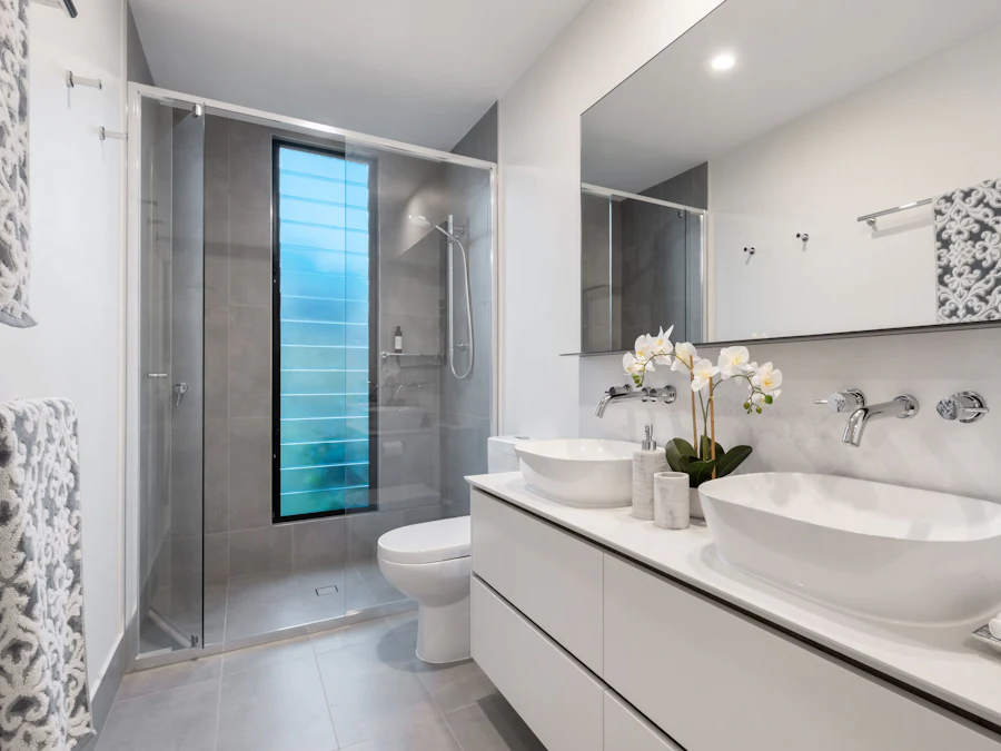 Newly fitted bathroom with a white vanity unit, countertop basin and large mirror